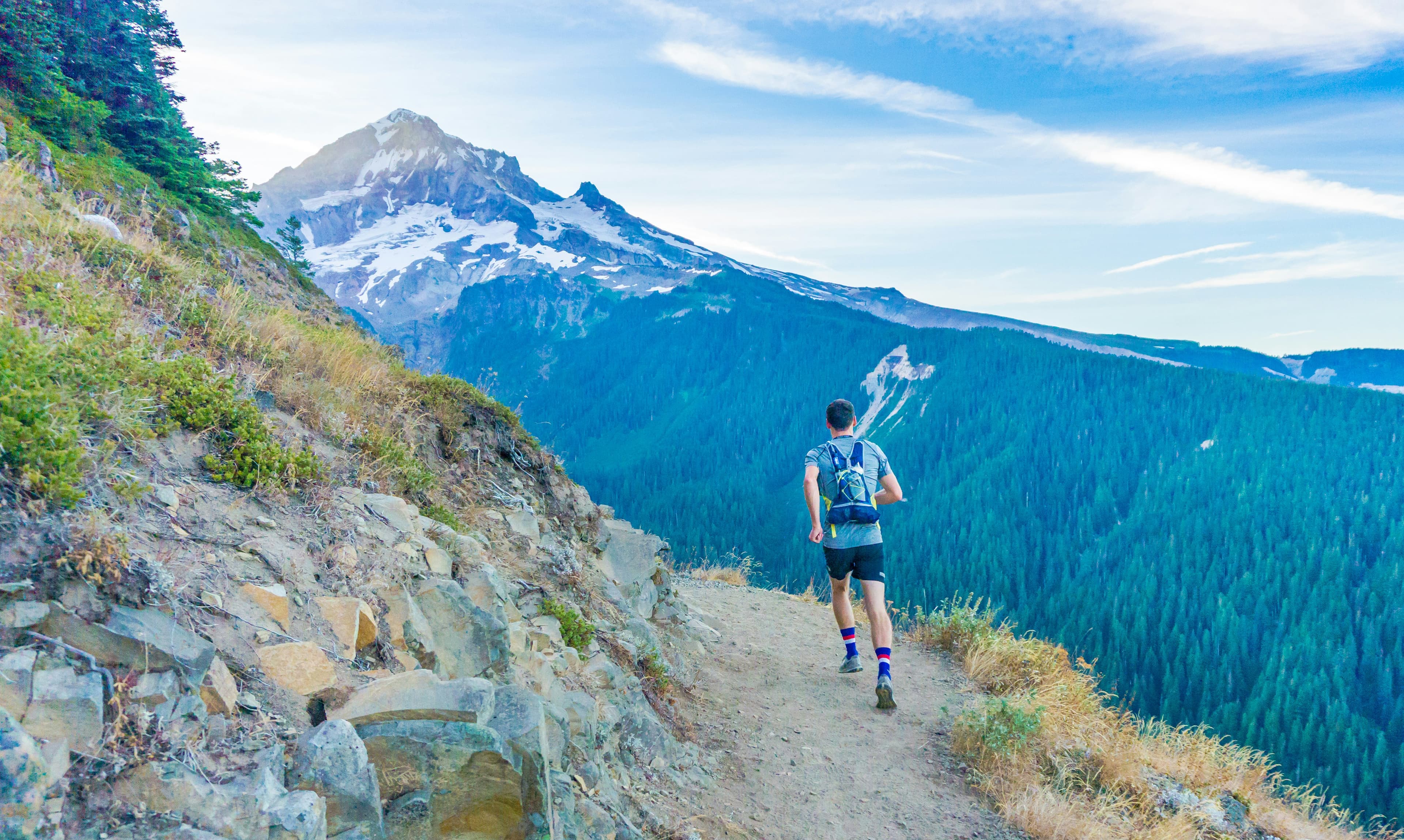 Coureur sur un sentier au bord d'une montagne