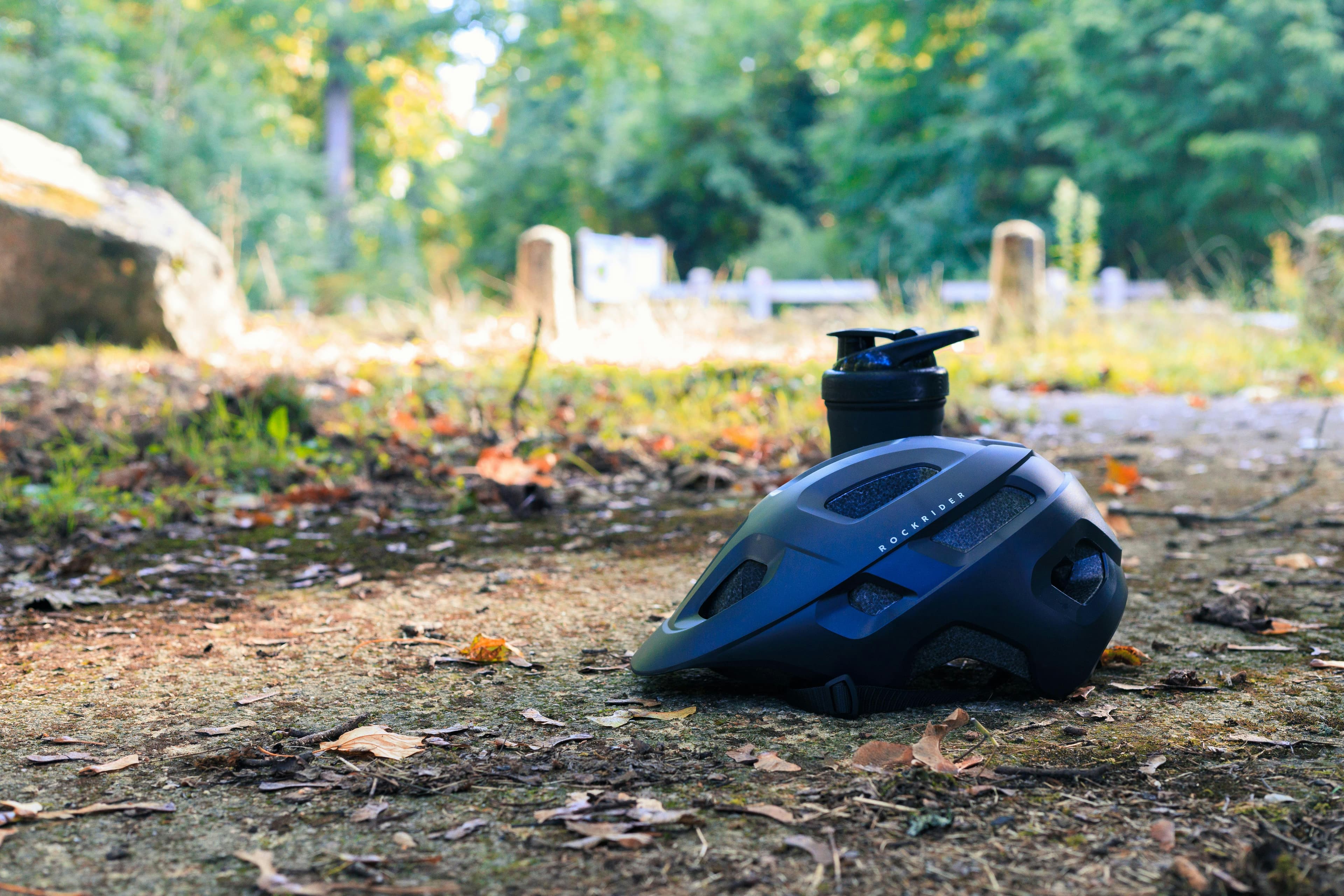 Casque de vélo et bouteille d'eau au bord d'un sentier